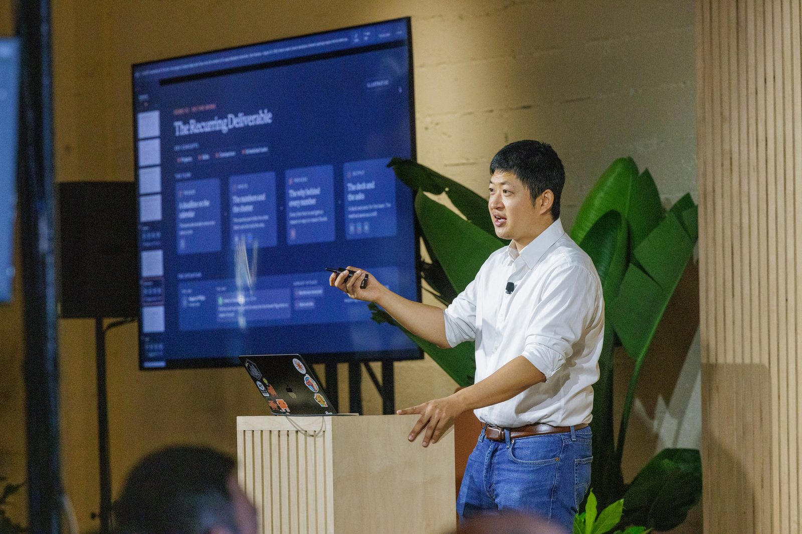 Kevin Bai presenting a Claude workflow on the screen behind him